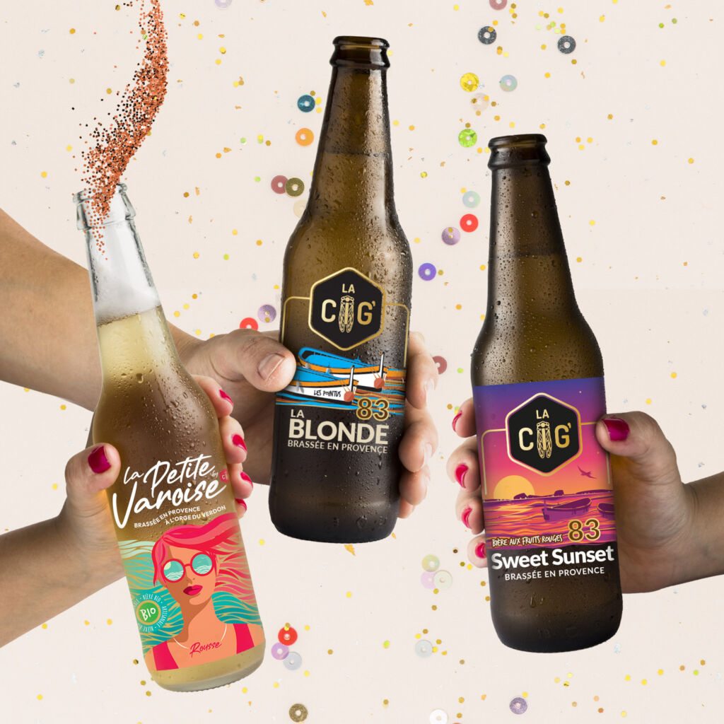 Trois mains qui trinquent avec bouteilles des bières festives et colorées, trois bouteilles de bières avec des étiquettes transparentes pour la brasserie La Cig, située à la Seyne-sur-Mer dans le Var, le logo et les étiquettes crées par Yunaima Oyola Yo Design située à Cherbourg-en-Cotentin