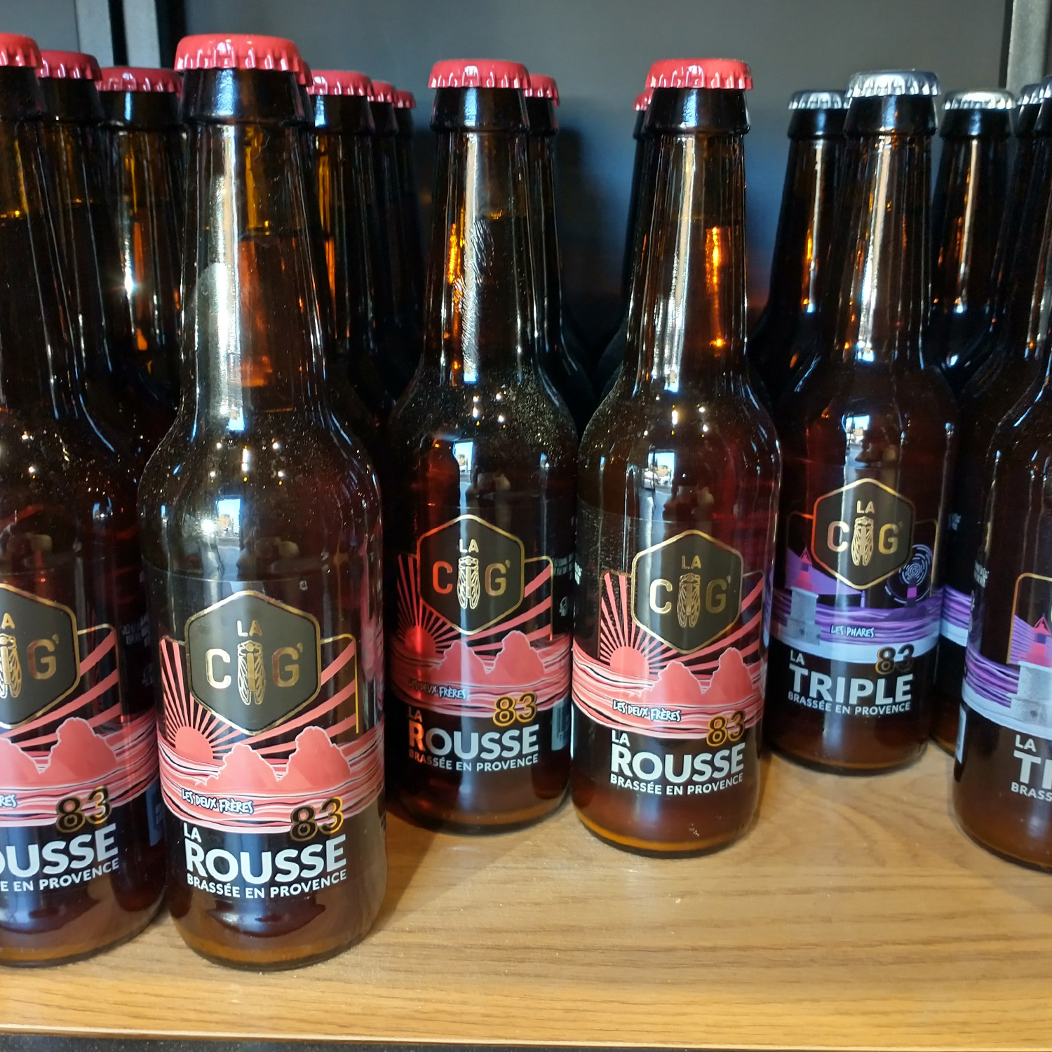 Ensemble des bouteilles de bières de la brasserie La Cig, située à la Seyne-sur-Mer dans le Var, avec des étiquettes transparentes et colorées crées par Yunaima Oyola Yo Design